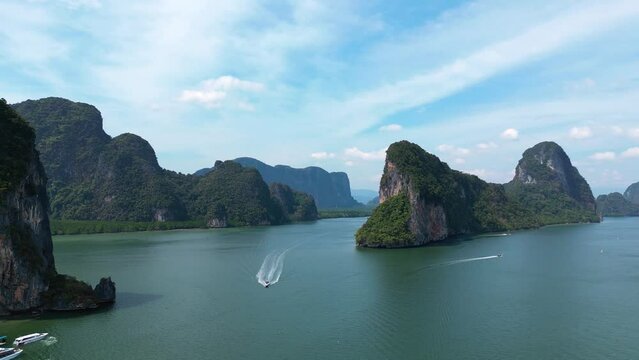 Drone view over a boat driving through rocky islands in Ko Panyi, Thailand