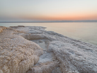 Rocky Beach With Salt Deposits in the Dead Sea at sunset, Jordan