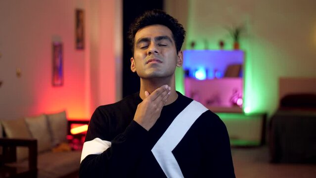 A sick & tired young indian man feels uneasy due to severe throat pain - illness  soar throat  pain  flu infection  changing weather . Pain in tonsil glands - disorder  disease  tonsil inflammation...
