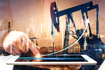 Businessman using digital tablet. Business global internet connection application technology digital marketing, Crude Oil pump oil rig energy industrial machine background. Crude oil increase price