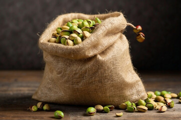 Raw pistachios spilling out from a burlap bag 