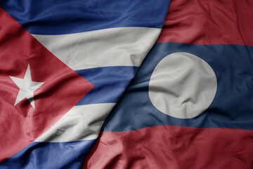 big waving national colorful flag of laos and national flag of cuba .