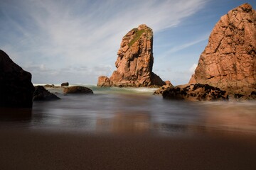 Majestic view of a rugged coastline in the horizon with a beautiful blue ocean in the foreground