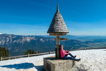 Hiker woman at wooden monument at Dreilaendereck, Karawanks, Carinthia, Austria. Triangle border...
