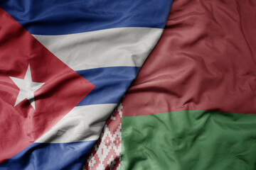 big waving national colorful flag of belarus and national flag of cuba .