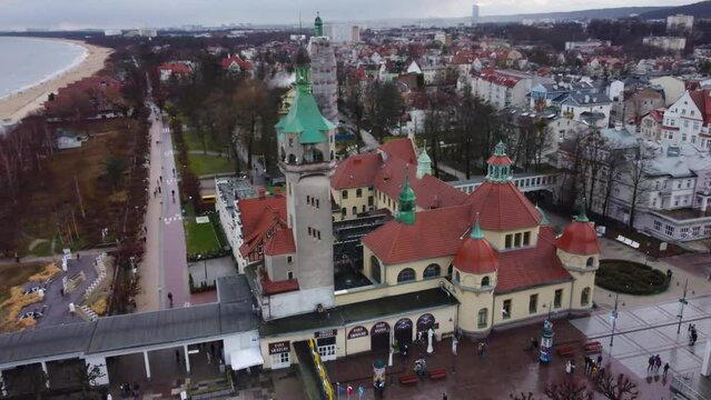 Aerial of the Sopot Lighthouse in Poland on a rainy day with a pier and sea in the background
