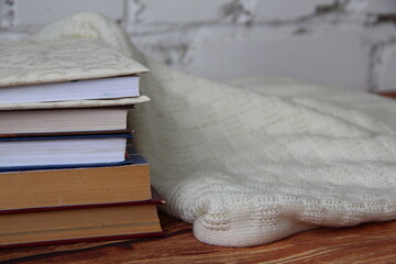 Stack of books and a cozy sweater near