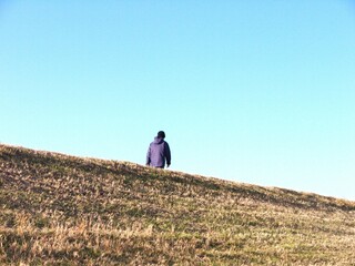 丘の上を歩く女性