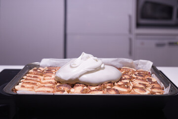 Baking of traditional roll apple cake with nuts, raisins and cinnamon covered with egg white snow