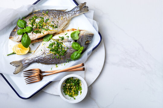 Baked dorado fish with gremolata, italian herb condiment. Copy space