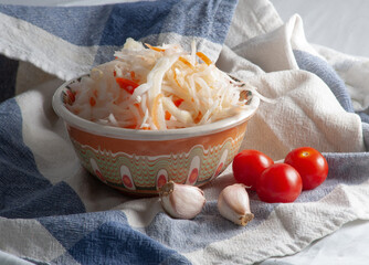 Sauerkraut in a bowl with pieces of garlic and cherry tomatoes