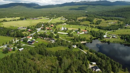 Aerial view of a picturesque town situated beside a tranquil lake surrounded by lush green forests