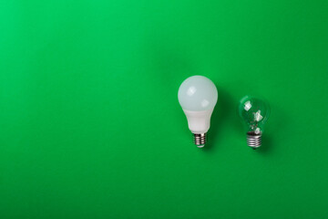 incandescent lamp and led lamps against on isolated green background. Energy efficiency concept....