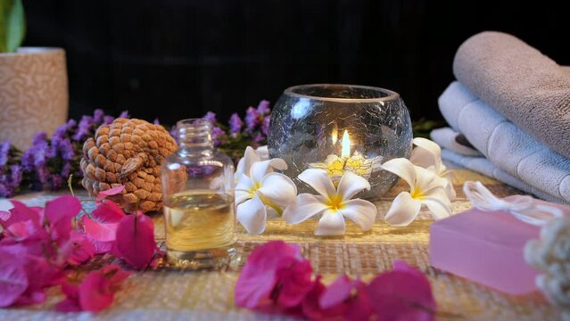 Medium shot of aromatic oil for wellness therapies and cosmetic treatments - beautiful spa table  essential oil. Rejuvenating natural oil for body massage in glass bottle - white flower  home aroma...