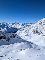 Picturesque landscape of majestic snowy mountain peaks with a beautiful blue sky background