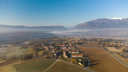 an aerial view of a country setting with fog over the valley and a town