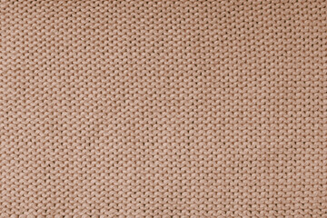 Close up background of knitted wool fabric made of viscose yarn, brown color wool knitwear texture. Sweater, pullover knitted jersey background. Fabric abstract backdrop, wallpaper