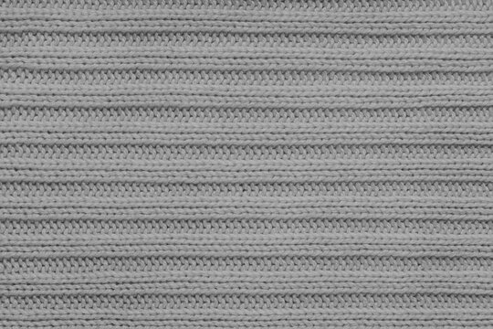 Jersey textile background , gray striped knitted fabric. Woolen knitwear, sweater, pullover surface texture, textile structure, cloth surface, weaving of knitwear material. Wallpaper, backdrop.
