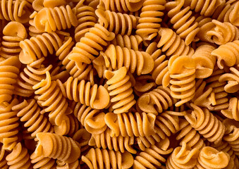 Texture of Organic Italian Chickpea Fusilli Pasta in a Wooden Bowl. Gluten-Free, Grain-Free, and Vegan Pasta. Healthy Eating Concept. Pasta Background.