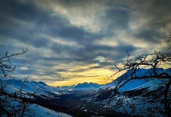A beautiful glowing sunset sky over the snowy mountains in Arctic Valley, Alaska