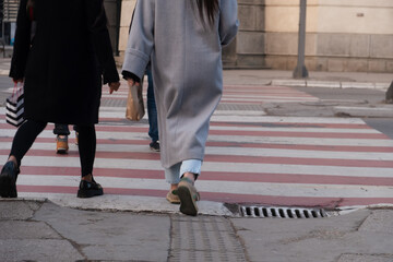 People crossing the street in the city, closeup of legs and shoes 