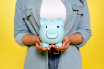 woman in denim shirt saving money for rainy day in the piggy bank, investment, saving money,...