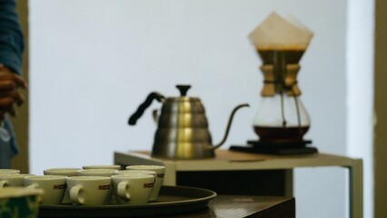 Wooden table adorned with white ceramic mugs and plates filled with freshly roasted coffee beans