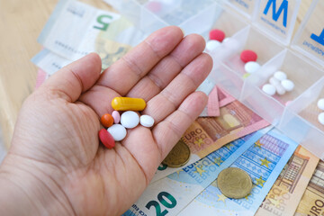 euro banknotes, coins, pills, vitamins in female palm, pillbox organizer for week, expensive medicines sick person, financial support for patient, ensuring medication adherence, promoting health