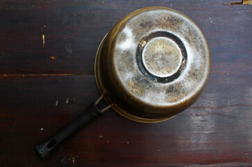 Top view of a pan placed upside down on a wooden board.