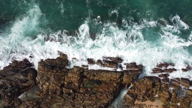 Drone shot over waves breaking the rocky coast of Dikwella in Sri Lanka