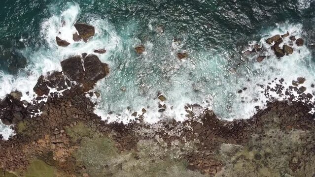 Drone view over sea waves covering a rocky coast in Dondra, Sri Lanka