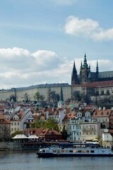 Obraz premium View of the Saint Vitus Cathedral in Prague, Czech Republic, with a riverboat in the foreground