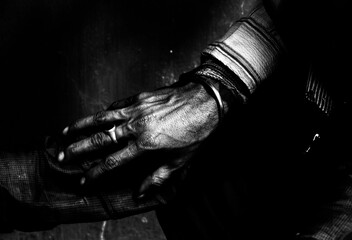 Close-up of a man's hand with a ring in darkness.