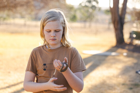 Pre-teen adolescent boy holding pet children's python snake