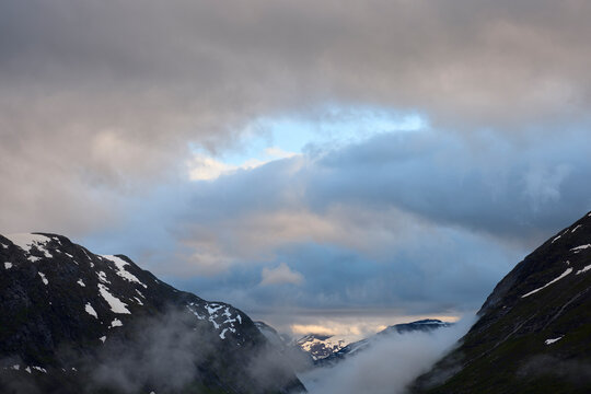Idyllic view of snow om mountains against cloudy sky