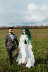 a bearded groom and a girl with green hair dance and twirl