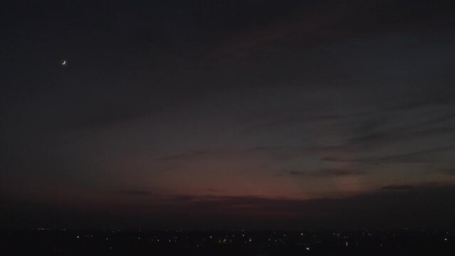 Delhi's sunset skyline was captured in a drone shot with airplanes and the moon in the crimson sky.