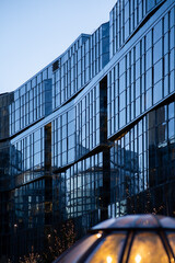Modern Glass Building Facade at Dusk with Interior Lights