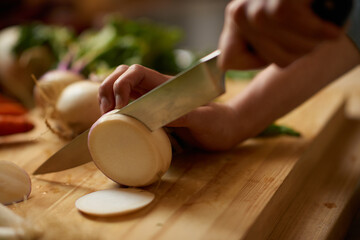 Person, hands and turnip chop for salad with knife, wellness and health in a home for nutrition....