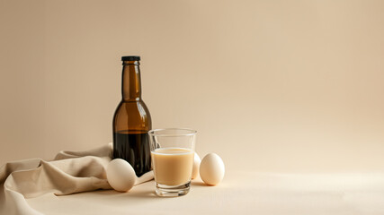 Fototapeta na wymiar liquor in small glass and dark bottle on the light beige studio background, minimalism style