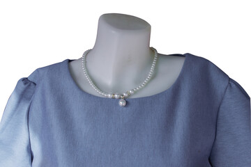 mannequin is wearing a blue shirt and pearl necklace.