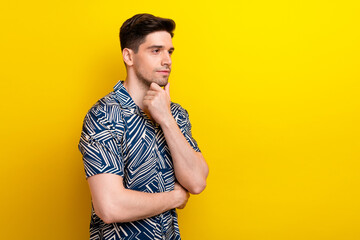 Photo of pensive puzzled man with stylish hairdo dressed blue clothes look at offer emppty space isolated on yellow color background