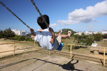 沖縄県宮古島　ブランコで遊ぶ子供