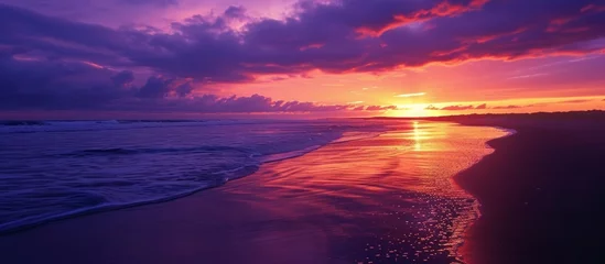 Rolgordijnen Experience the breathtaking beauty of a dusk landscape as the purple sky blends with the clouds, water, and fluid atmosphere over the beach. © AkuAku