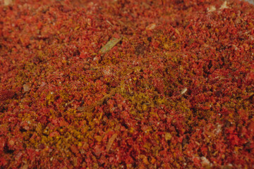Assorted seasonings in a pile. Background of red paprika powder. Close up of red paprika in a spice shop, texture.