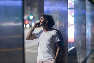 Fototapeta premium View of young man using a smartphone at night