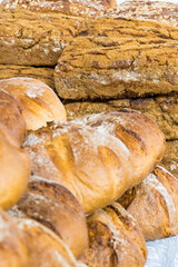 Fresh traditional loaves of wheat or rye bread on stall or in bakery