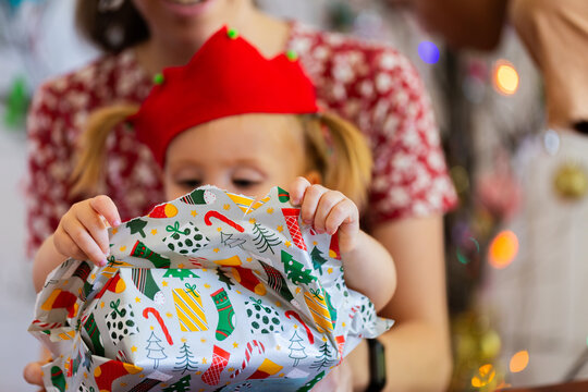 Toddler opening gift at Christmas