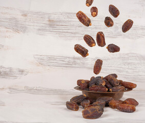 Date fruit Ramazan concept image. Dropping, falling, flying, raining. Wooden white painted background. Copy space. Heap of ramadan Iftar stater food, date fruit concept image idea.