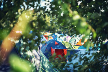 Many tents, camping and outdoor in nature for a music festival. Row of rainbow marquees placed on...